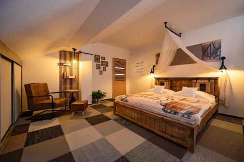 a bedroom with a bed and a chair in a room at Maravar - Beer Spa - Adults Only in Liptovský Trnovec