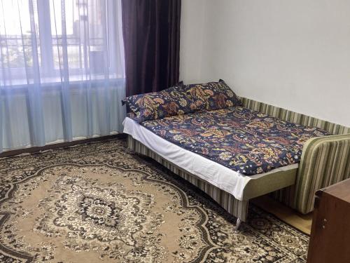 a small bed in a room with a window at Golden House in Khust