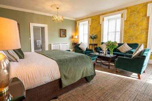 a bedroom with a bed and chairs and a table at Falls Hotel & Spa in Ennistymon