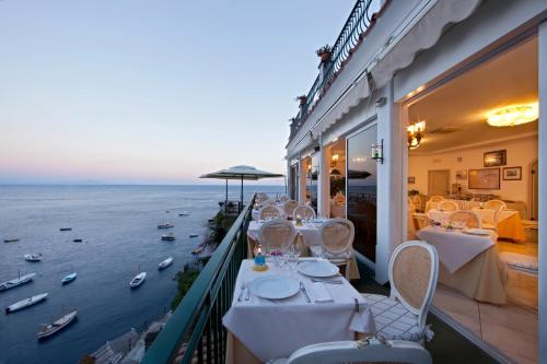 a restaurant with a balcony with a view of the water at Villa Corallium in Praiano