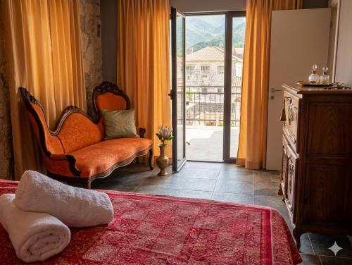 a bedroom with a chair and a door to a balcony at Loft in Kruce in Kruče