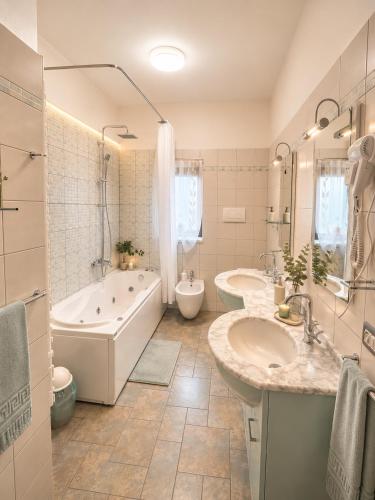 a bathroom with two sinks and a tub and a toilet and a bath tub at Bellavista B&B in Roccavivara
