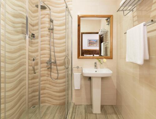 a bathroom with a sink and a shower at Voilà Beau Vallon in Beau Vallon