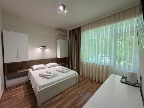 a bedroom with a bed and a large window at Hotel Captain in Gonio