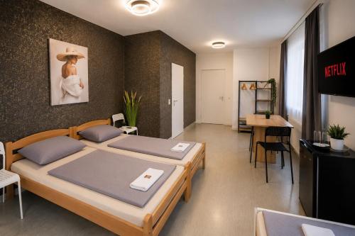 a room with two beds and a table and a tv at Moderne Appartement in Nuremberg