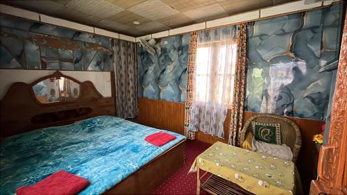 a bedroom with a bed and a chair in it at Hotel sea face in Srinagar