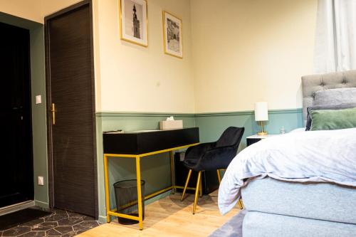 a bedroom with a bed and a desk and a bed at La Suite Fernand Bar in Béthune
