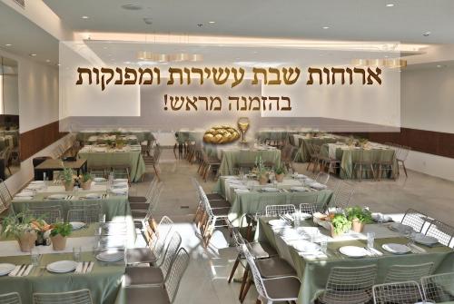 a dining room with green tables and chairs at Residence Beach Hotel in Netanya