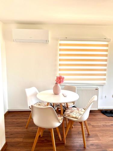 a white dining room with a table and chairs at Apartman Rosić in Arilje