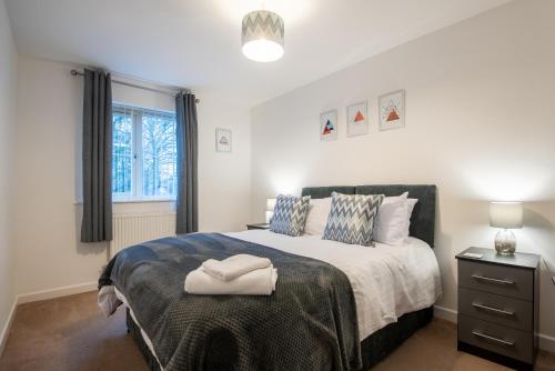 a bedroom with a large bed and a window at No12, Modern 2 Bedroom Apartment in Mansfield