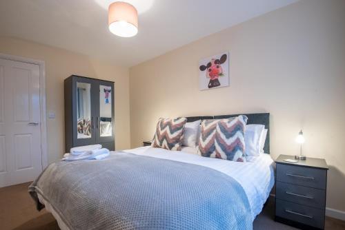 a bedroom with a large bed with a blue blanket at No12, Modern 2 Bedroom Apartment in Mansfield