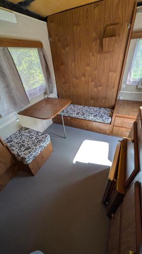 an interior view of an rv with a table and bench at Caravane Cosy - 5min Circuit 24h du Mans in Changé