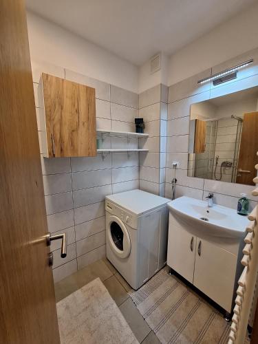 a bathroom with a washing machine and a sink at Apartment Stup Sarajevo in Sarajevo
