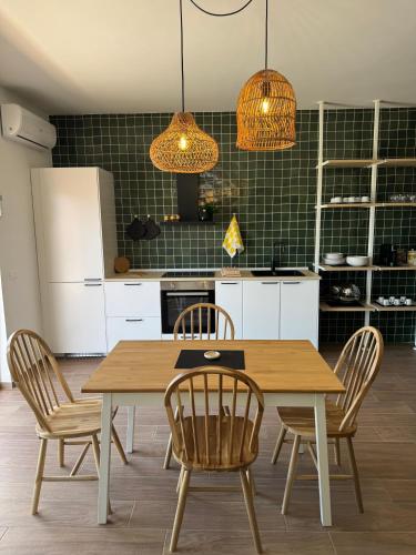 a kitchen with a wooden table and chairs at Almaré Luxury Beach Apartments in Taranto
