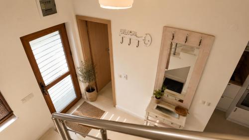 a hallway with a mirror and a chair at Guest House Forest 20 in Balchik