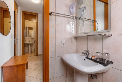 a bathroom with a sink and a mirror at Hotel Adria in Malinska