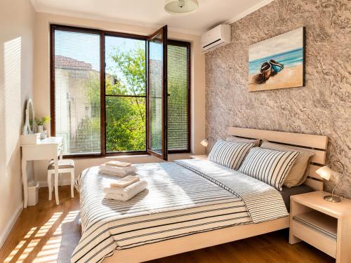 a bedroom with a large bed and a large window at Guest House Forest 20 in Balchik