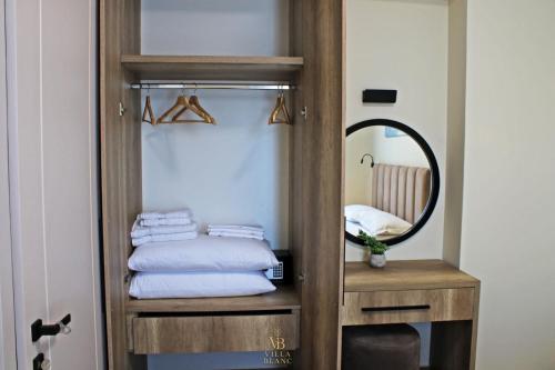 a bathroom with a mirror and a wooden closet at Villa Blanc in Shëngjin