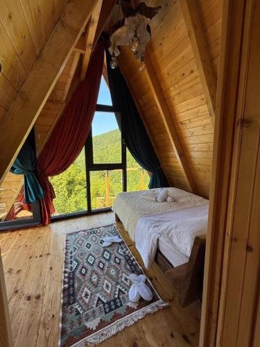 a bedroom with a bed in a room with a window at MOSES HOUSE-მოსეს სახლი in Baladzeyebi