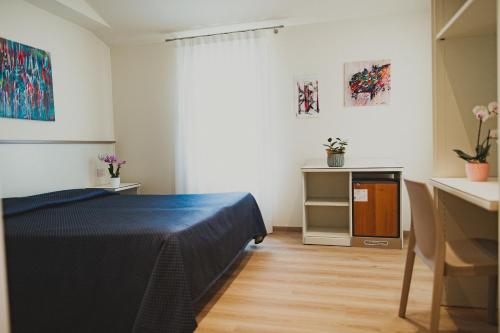 a bedroom with a bed and a table and a desk at Hotel Magnolia in Preganziol