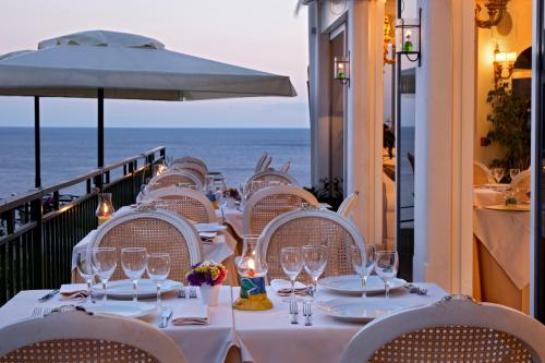 a table with wine glasses and a view of the ocean at Villa Corallium in Praiano