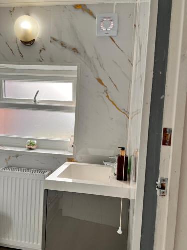 a white bathroom with a sink and a mirror at Ayetonis in Pallion
