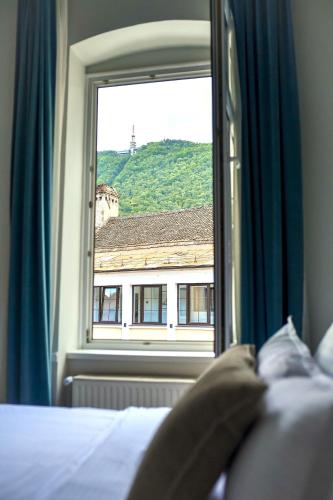 a bedroom with a window with a view of a building at Casa Baritiu Rooms in Braşov