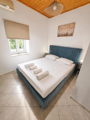 a bedroom with a large bed with two towels on it at Nature's Nook Paxos in Vlachopoulátika