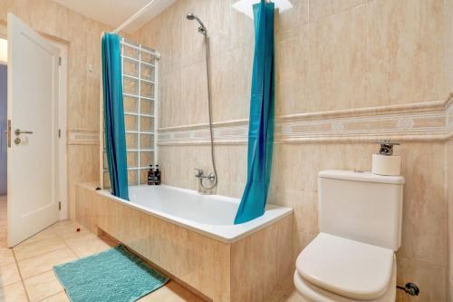 a bathroom with a tub and a toilet and a shower at Refugio del Viento in Antigua