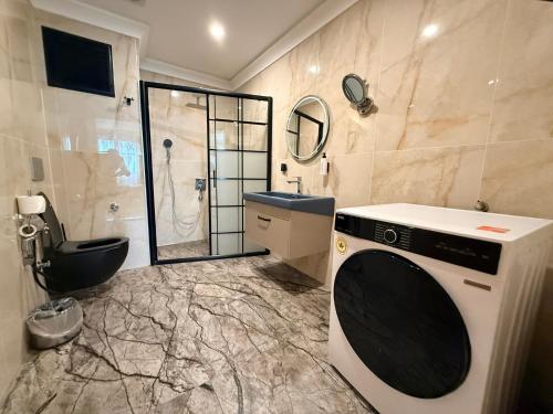 a bathroom with a sink and a washing machine at Rena Grand Residence & Suit in Trabzon