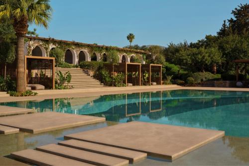 a swimming pool in a villa with trees and stairs at Minos Beach Art Hotel, a Member of Design Hotels in Agios Nikolaos