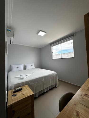 a bedroom with a bed and a desk and a window at Danny's Hotel in Tailandia