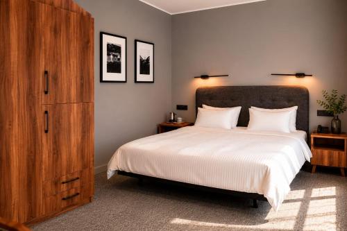 a bedroom with a large bed and a wooden cabinet at Hotel Chiatureli in Chiatʼura