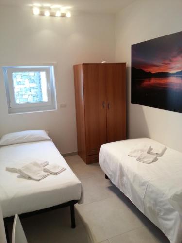 a room with two beds and a tv on the wall at Residence Il Poggio in Dorio