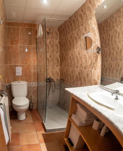a bathroom with a shower and a toilet and a sink at Hotel Ransol in El Tarter