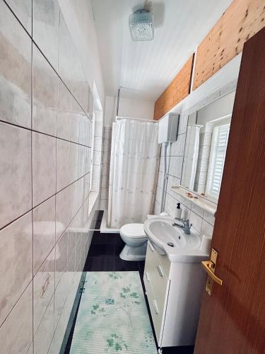 a bathroom with a sink and a toilet at room MLIN 1 in Lun
