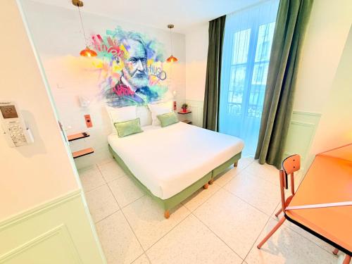 a bedroom with a bed and a painting on the wall at Hotel La Petite Rosa in Paris