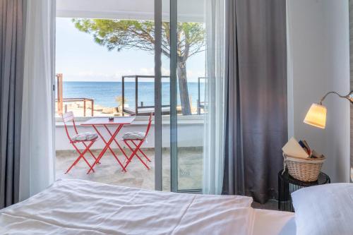 a bedroom with a bed and a view of the ocean at Barbara Piran Beach Hotel in Piran