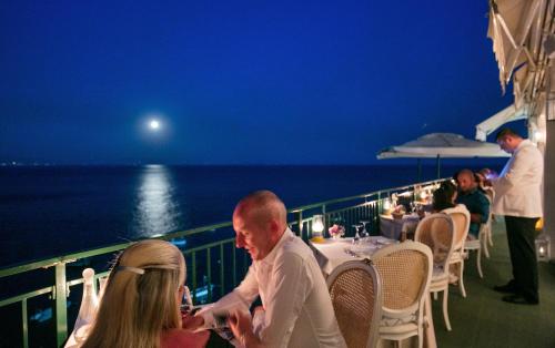 a group of people sitting at a table on a cruise ship at Villa Corallium in Praiano