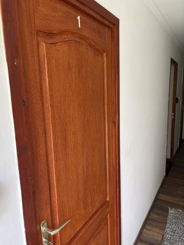 a wooden door in a room with a hallway at Kincső Vendégház Siófok in Siófok
