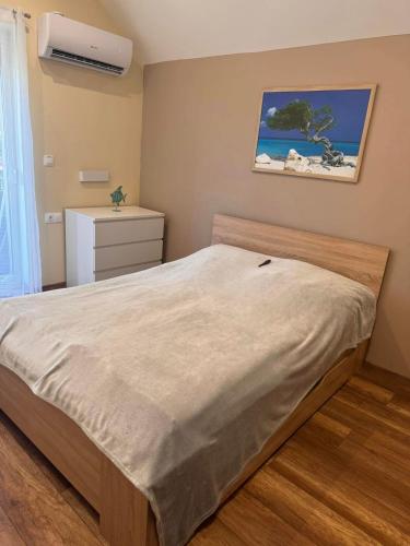 a bedroom with a large bed and a dresser at Felüdülő Apartman Balatonlelle in Balatonlelle