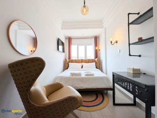 a bedroom with a bed and a chair and a mirror at Chic apart with a view in Yaoundé