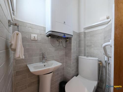 a small bathroom with a toilet and a sink at Chic apart with a view in Yaoundé