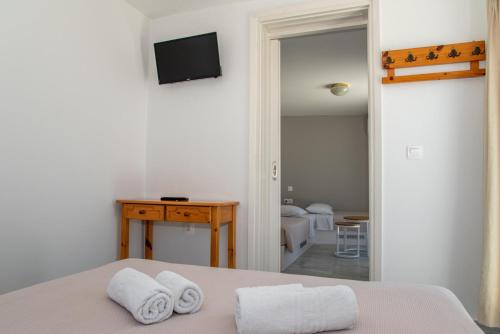 a bedroom with a bed with towels on it at Flora in Tinos