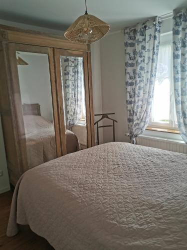 a bedroom with a bed and a mirror at La douce Campagne in Flavigny-le-Grand-et-Beaurain