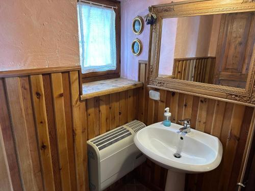 a bathroom with a sink and a toilet and a mirror at Maison Angèle in Saint Nicolas
