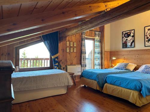 a bedroom with two beds and a window at Maison Angèle in Saint Nicolas
