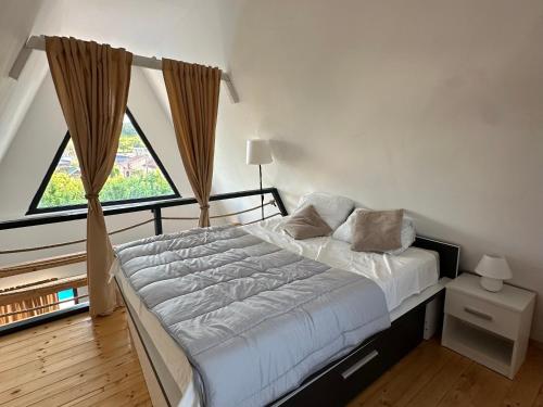a bedroom with a bed and a large window at Laganini house Vinča in Belgrade