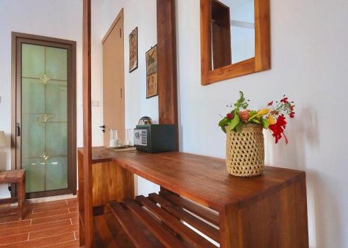 a room with a wooden table with a vase of flowers at Aurora Nungwi in Nungwi