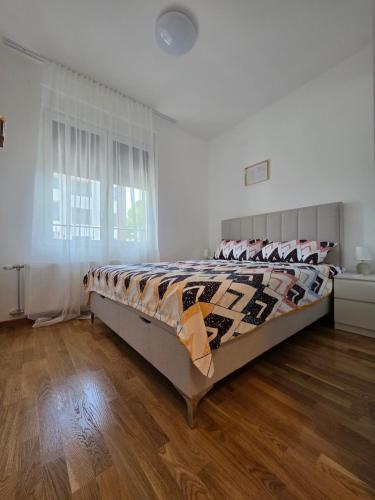 a bedroom with a large bed in a room at Gold Apartman in Pančevo